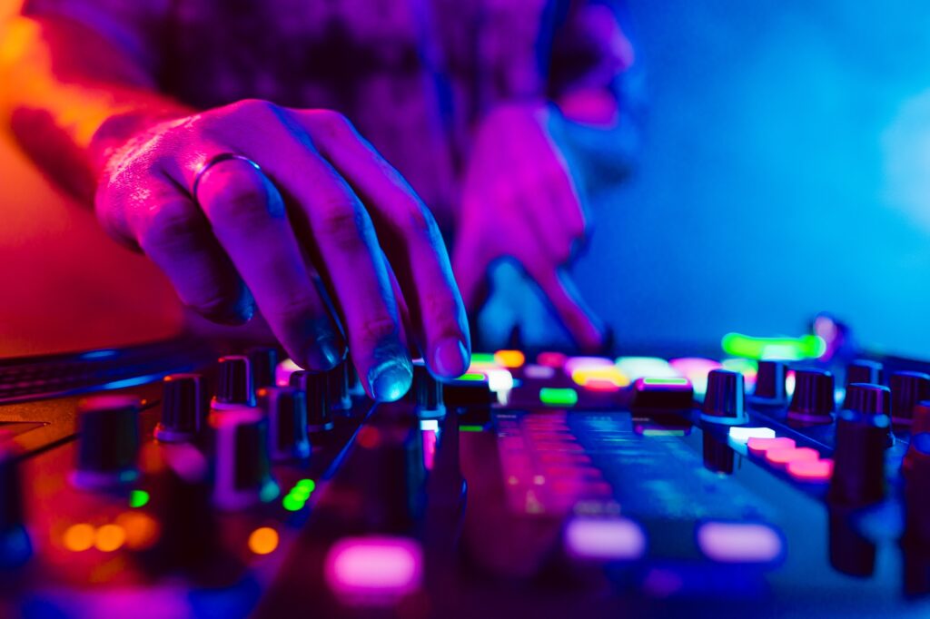 Close up of DJ hands on dj console mixer during concert in the club